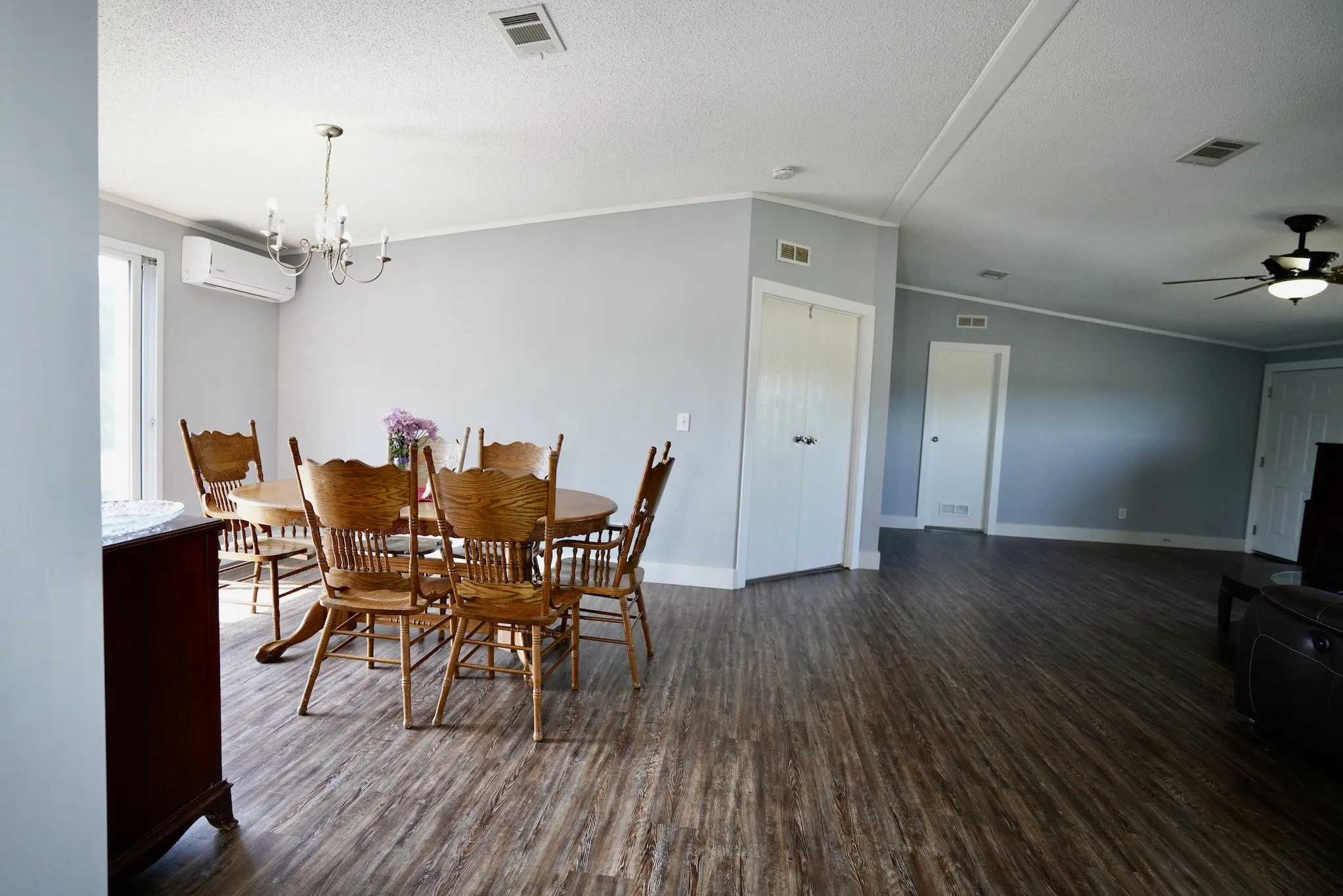 Dining room featuring crown molding, dark wood-type flooring, a chandelier, a textured ceiling, and a ceiling fan