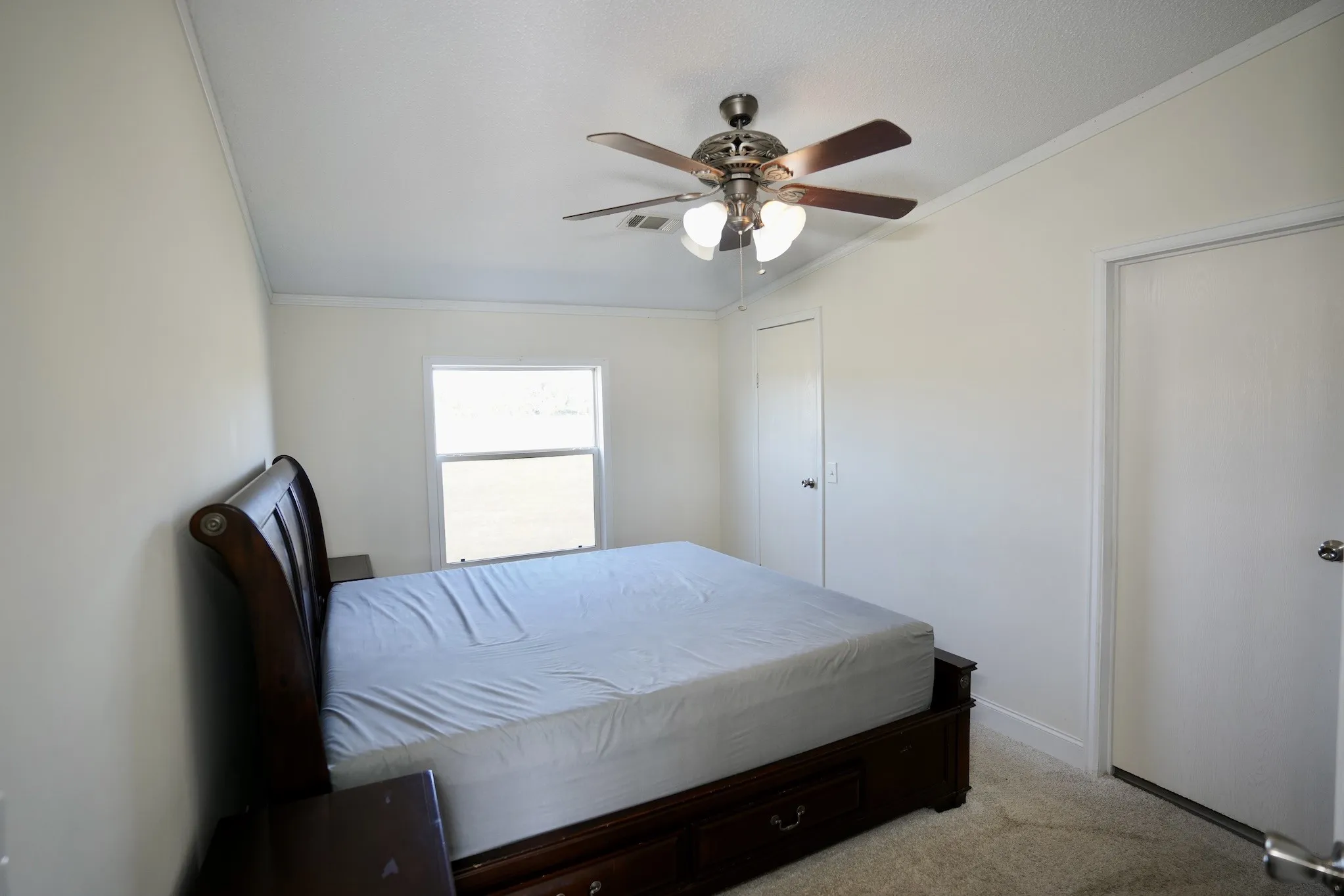 Carpeted bedroom with ornamental molding and a ceiling fan