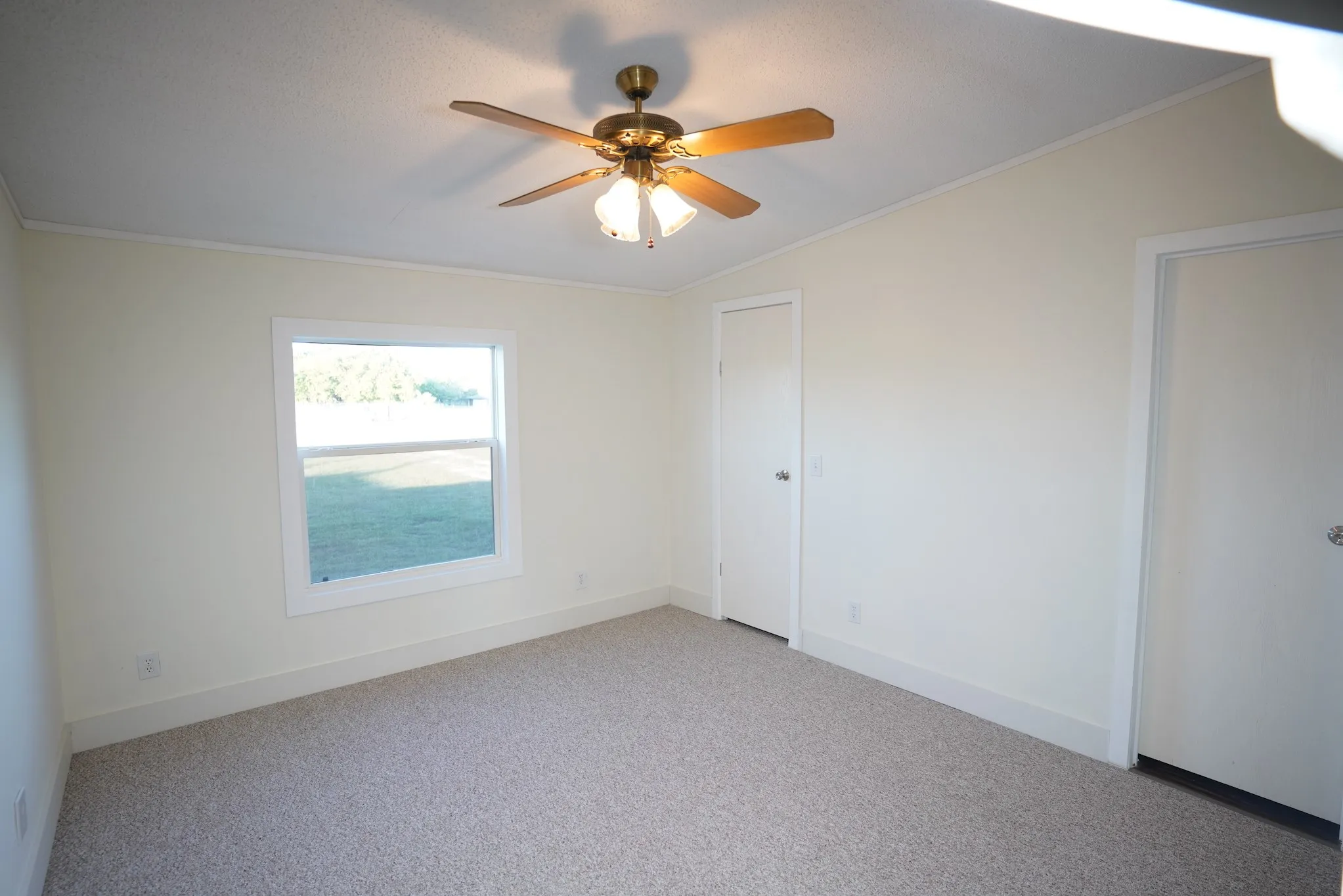 Empty room with ornamental molding, carpet, and ceiling fan