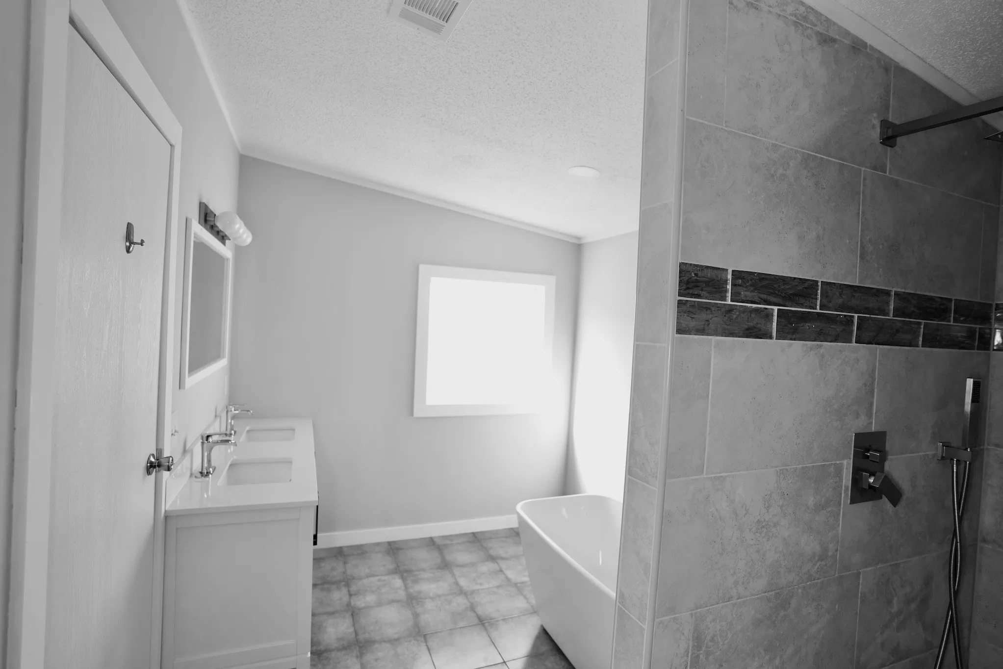 Bathroom with a freestanding tub, double vanity, a textured ceiling, and tiled shower