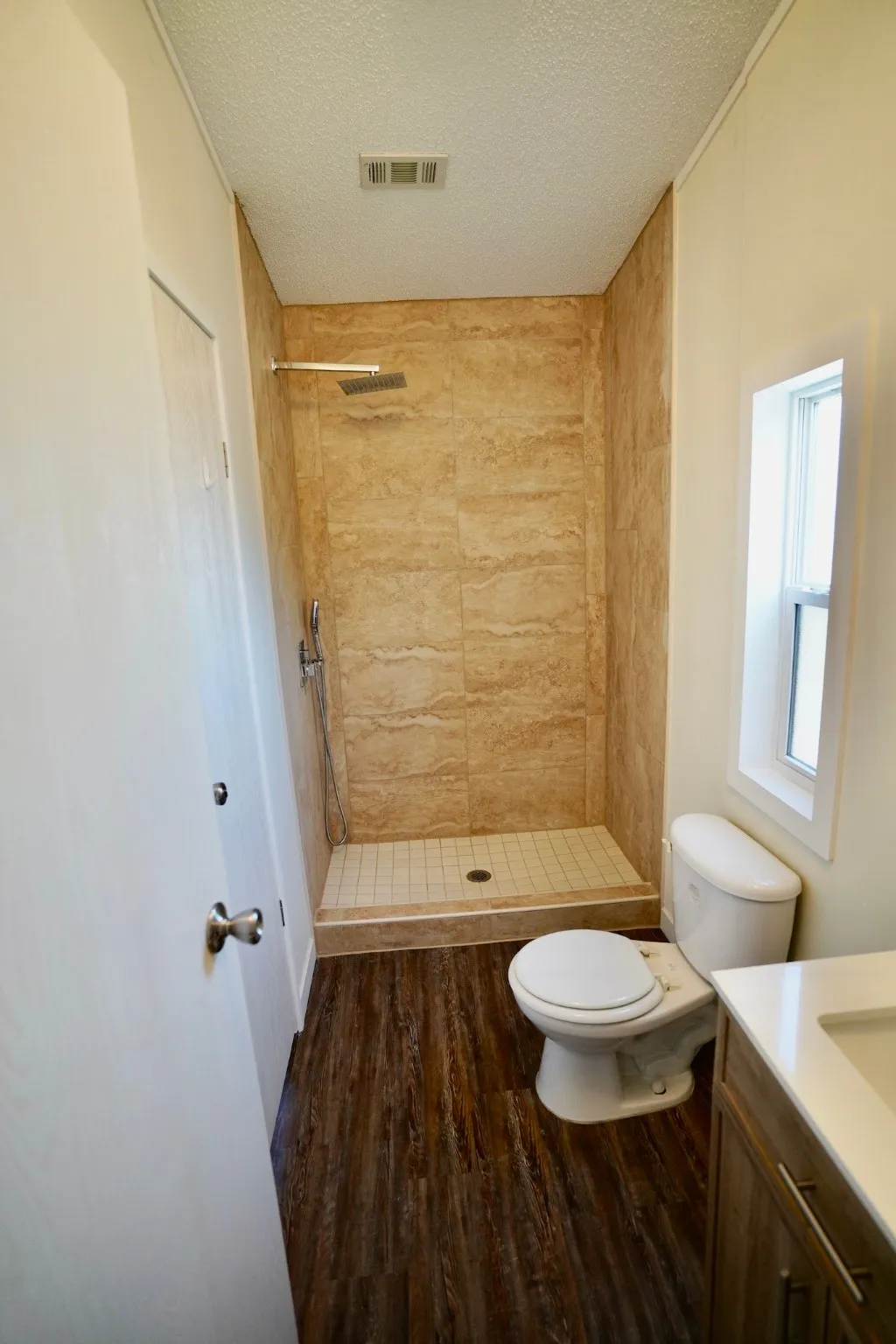 Bathroom with dark wood-style floors, vanity, a stall shower, and a textured ceiling