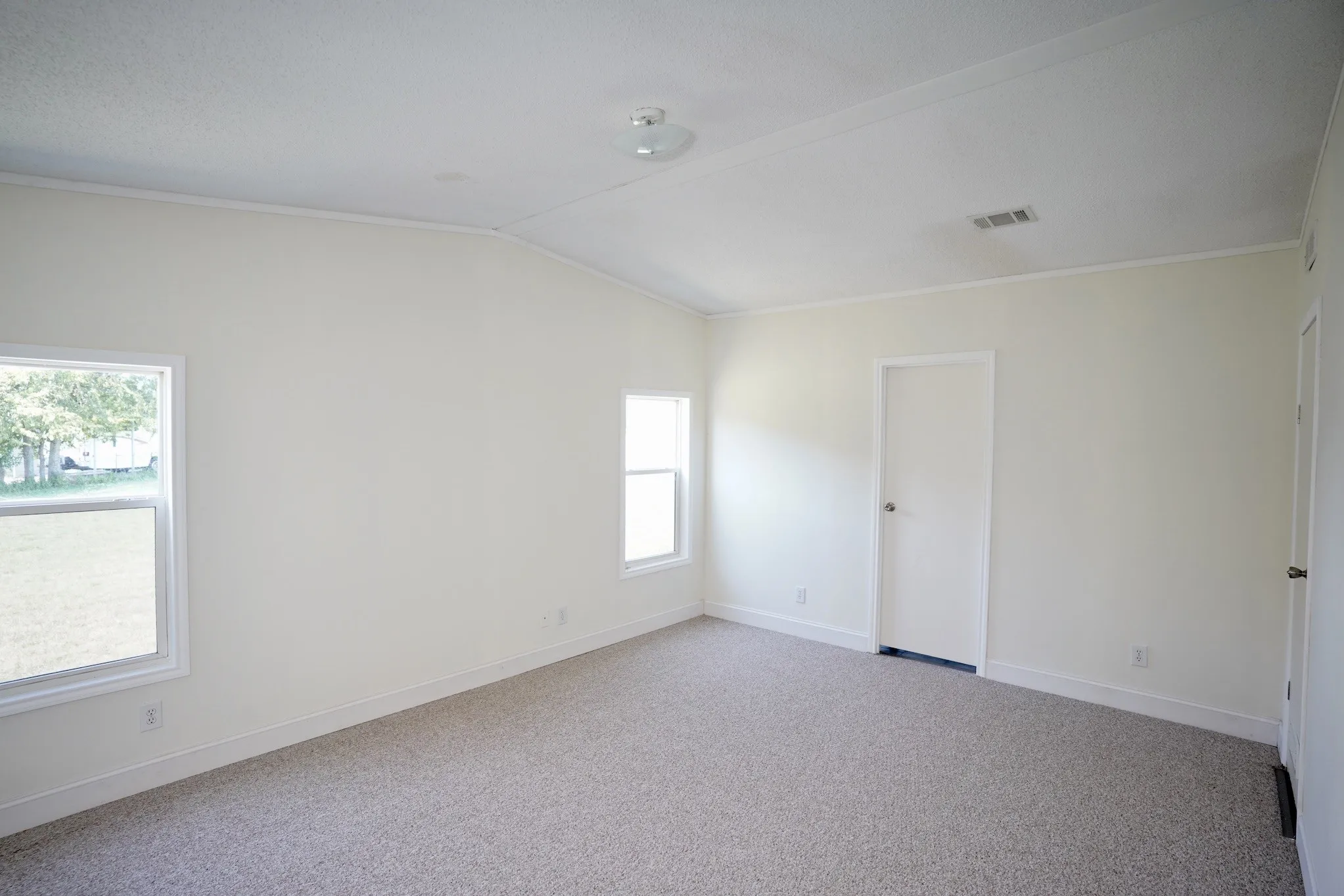 Spare room with carpet floors, lofted ceiling, and ornamental molding