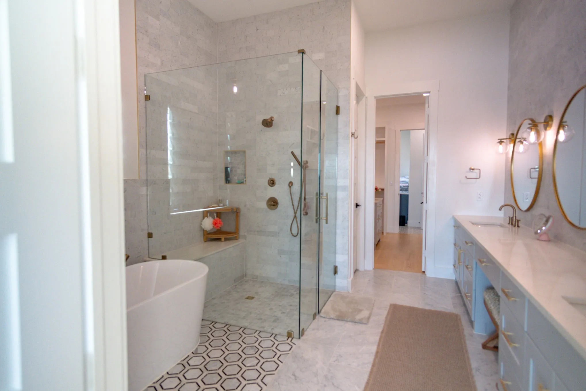 Bathroom with a soaking tub, a stall shower, double vanity, and light tile patterned floors