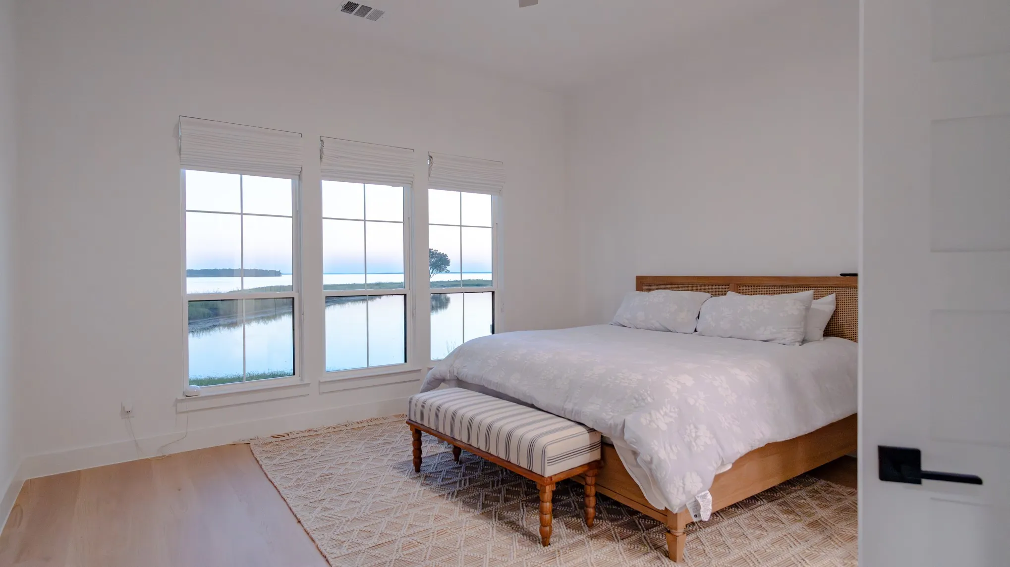 Bedroom featuring a water view, light wood-type flooring, and a ceiling fan