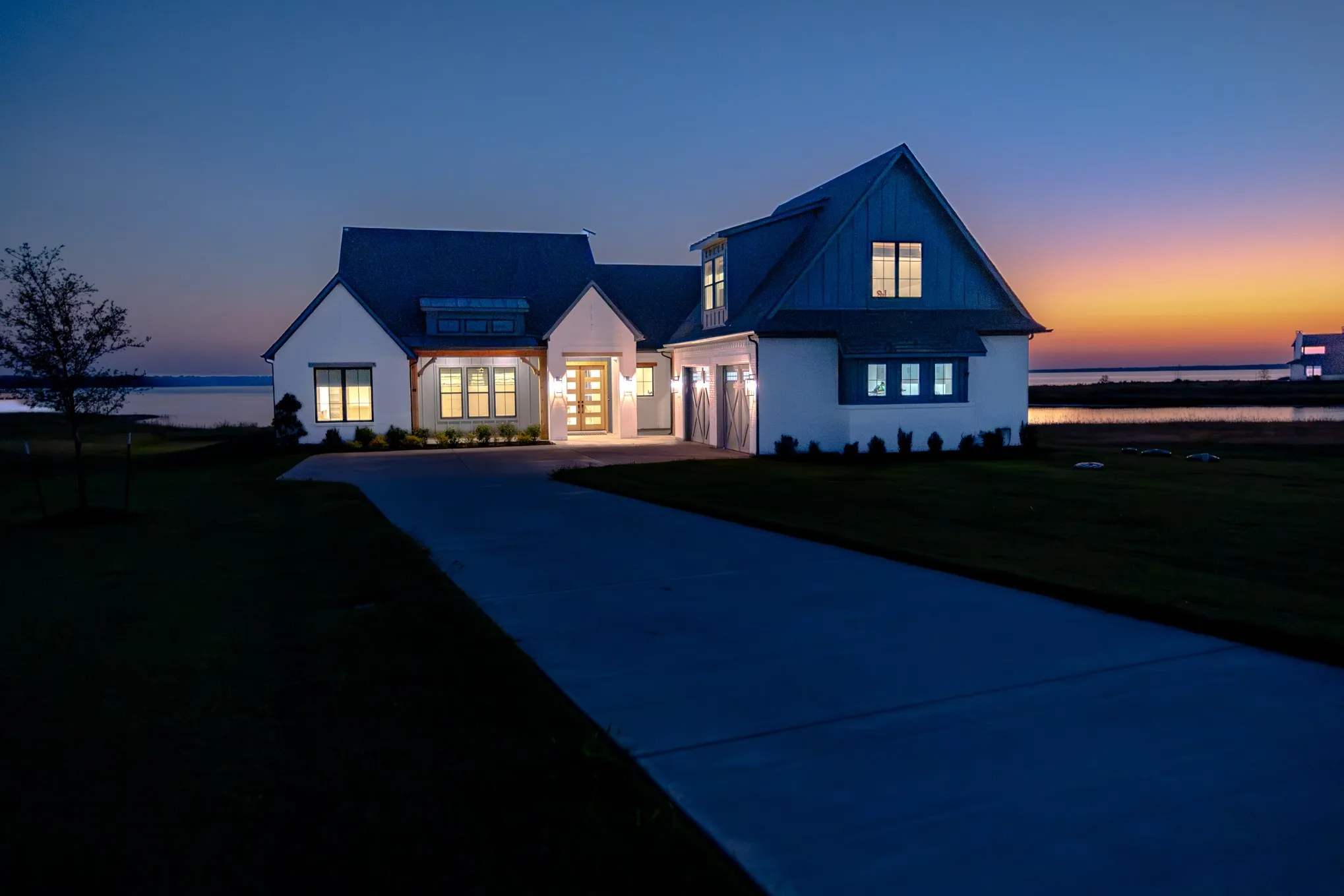 Modern farmhouse style home featuring driveway, a front yard, and a garage