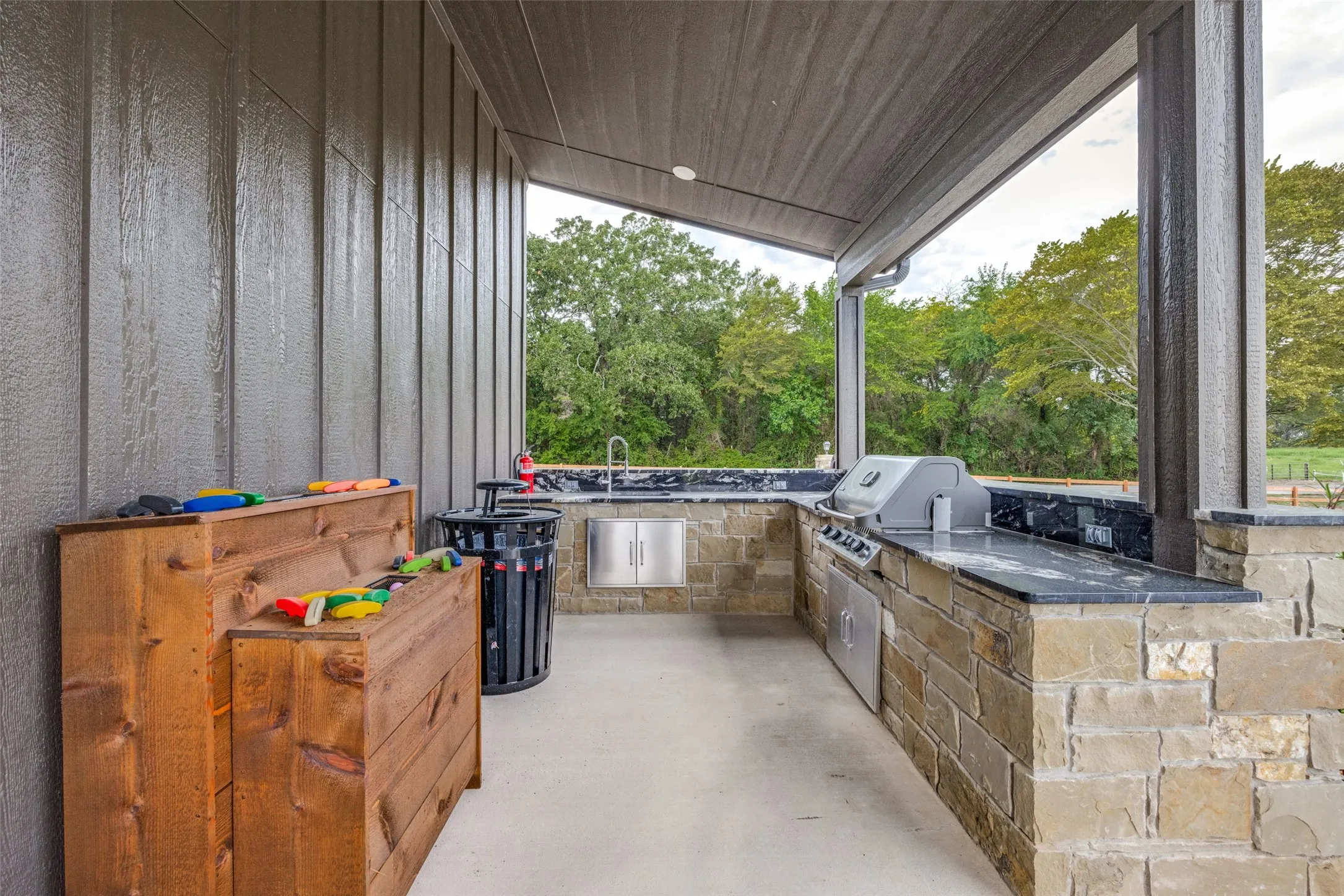 View of patio with an outdoor kitchen and view of scattered trees