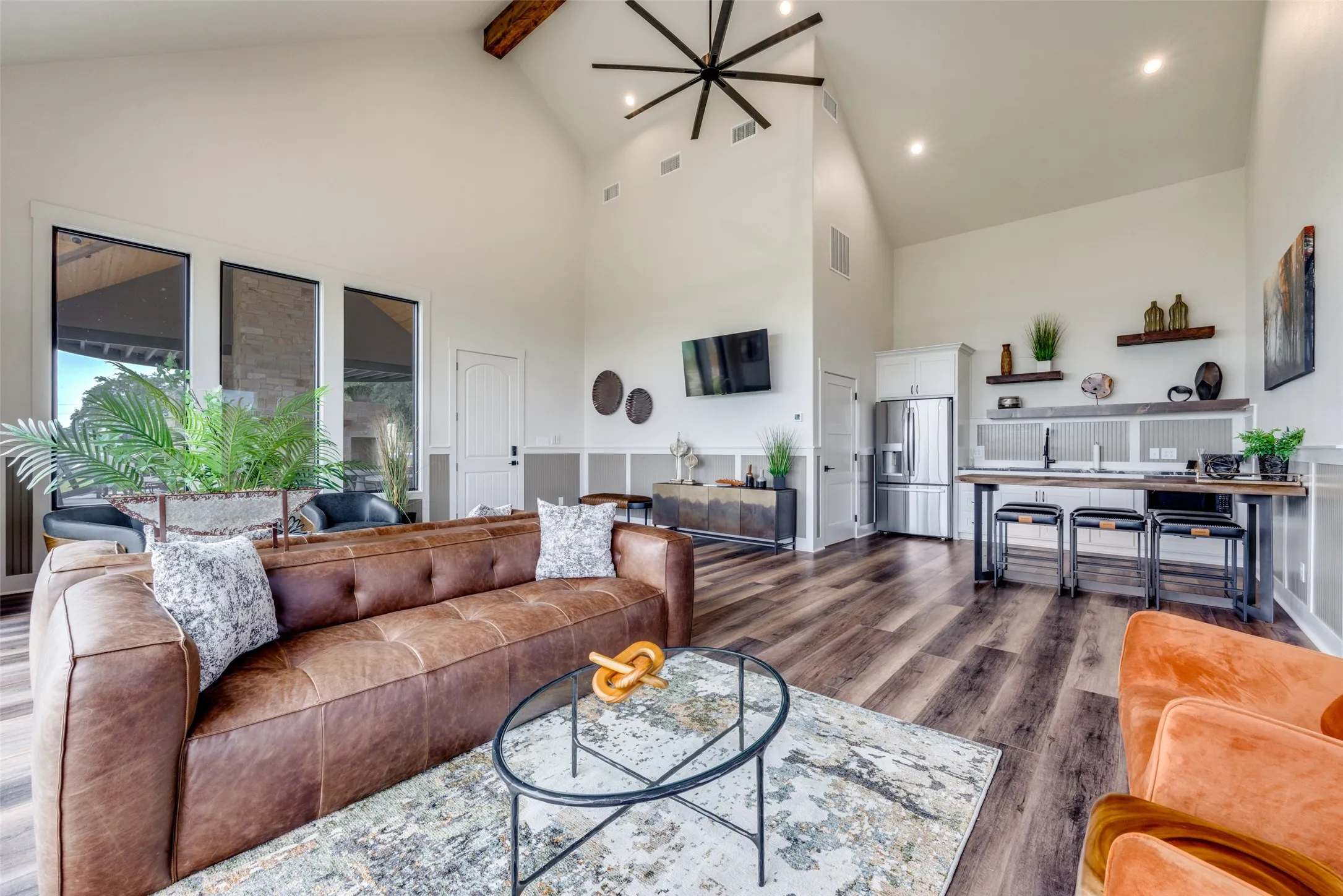 Living area featuring high vaulted ceiling, beamed ceiling, dark wood-style floors, and a chandelier