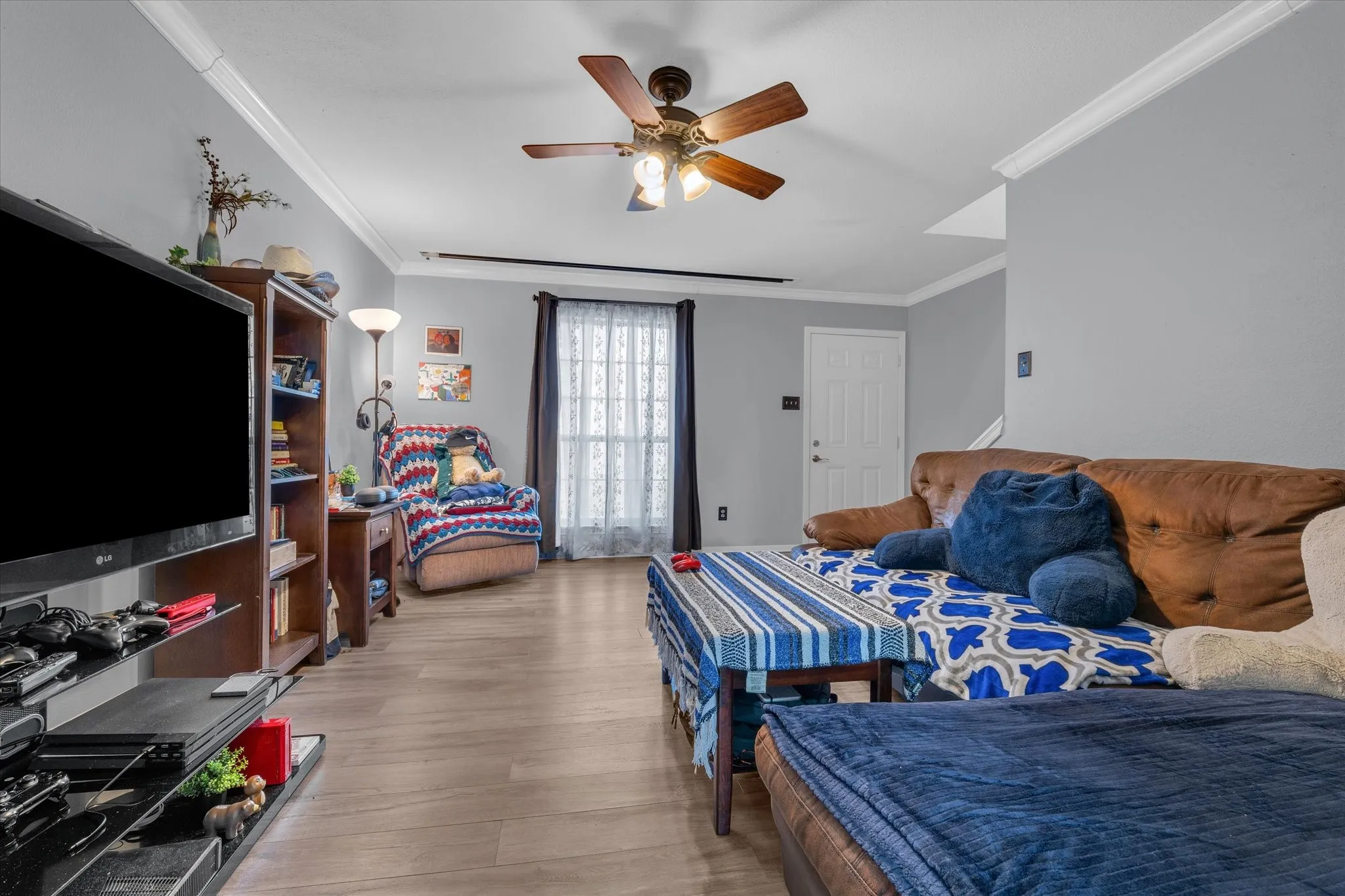 Bedroom with crown molding, ceiling fan, and light wood-style floors