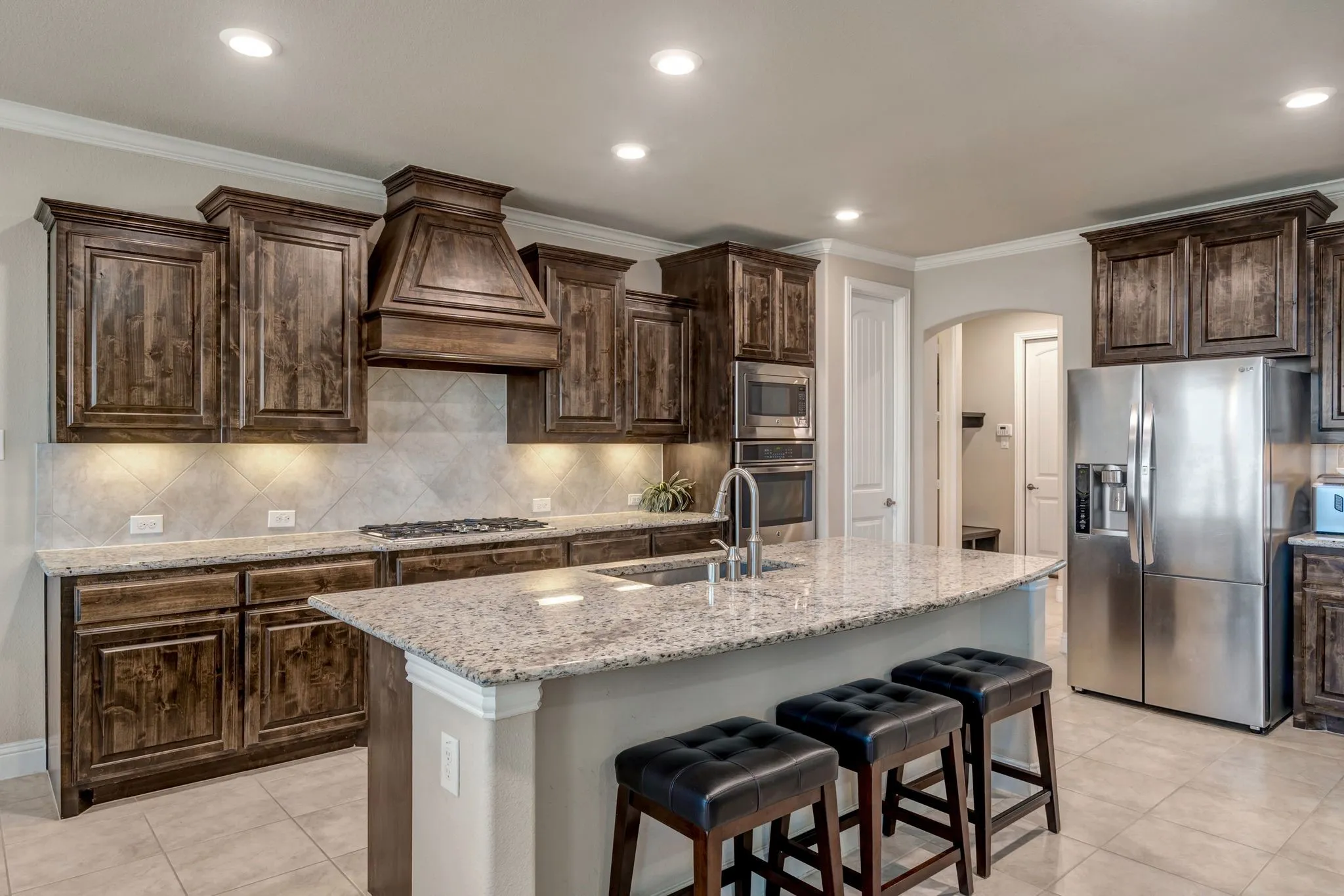 Spacious kitchen with stainless appliances,backsplash, crown molding, and arched walkways & more!