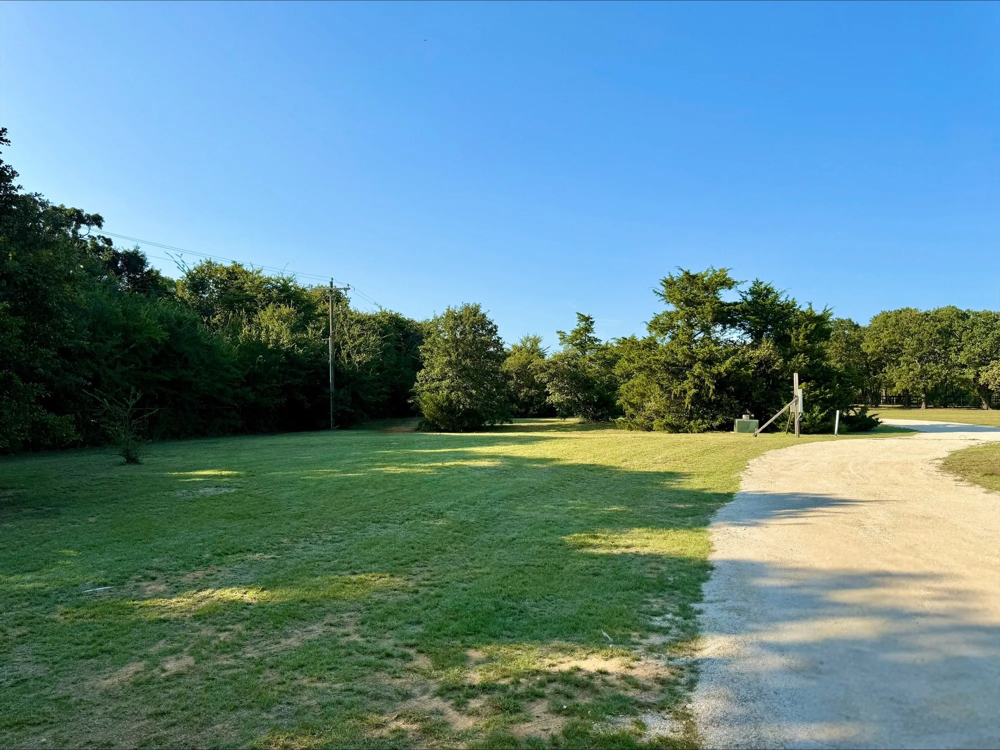 View of home's community featuring a lawn and a wooded view