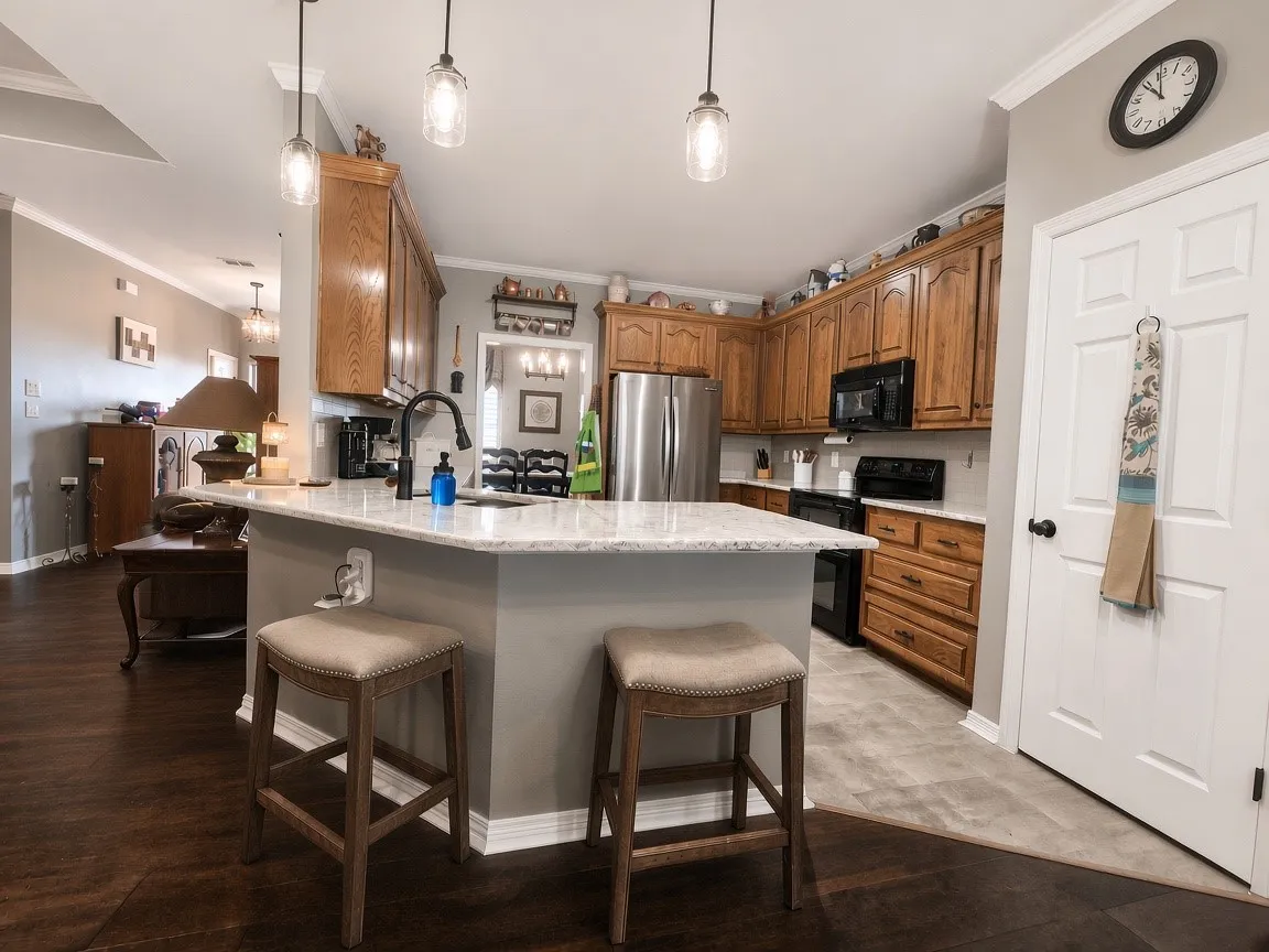 Kitchen featuring stone countertops, wood cabinetry, stainless steel appliances, and wood-finish flooring