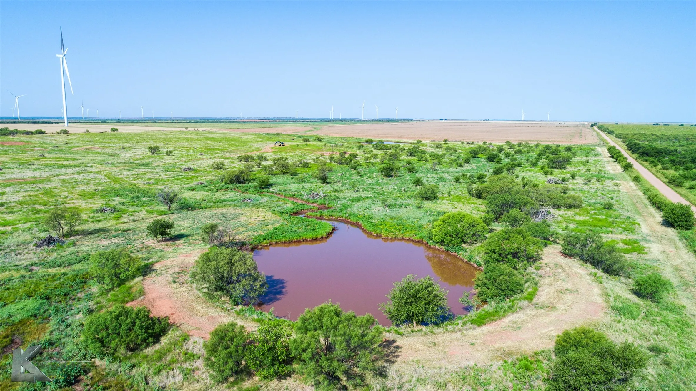 View of rural area with a nearby body of water and rows of crops