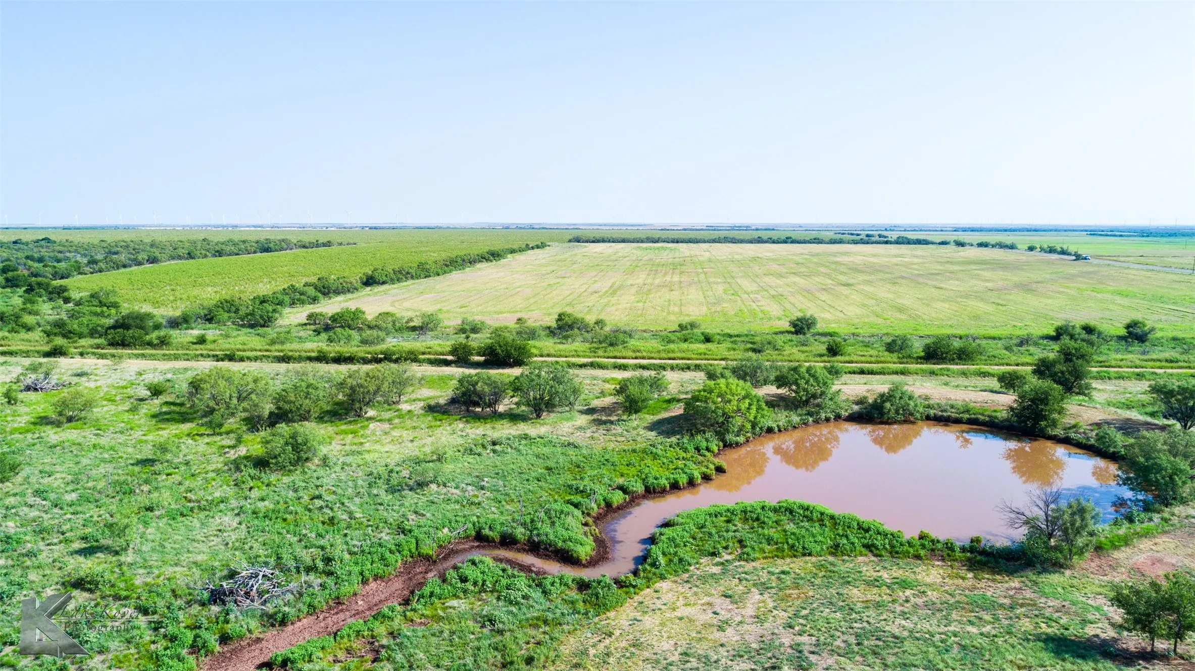 Aerial view of property's location featuring a nearby body of water, rural landscape, and rows of crops