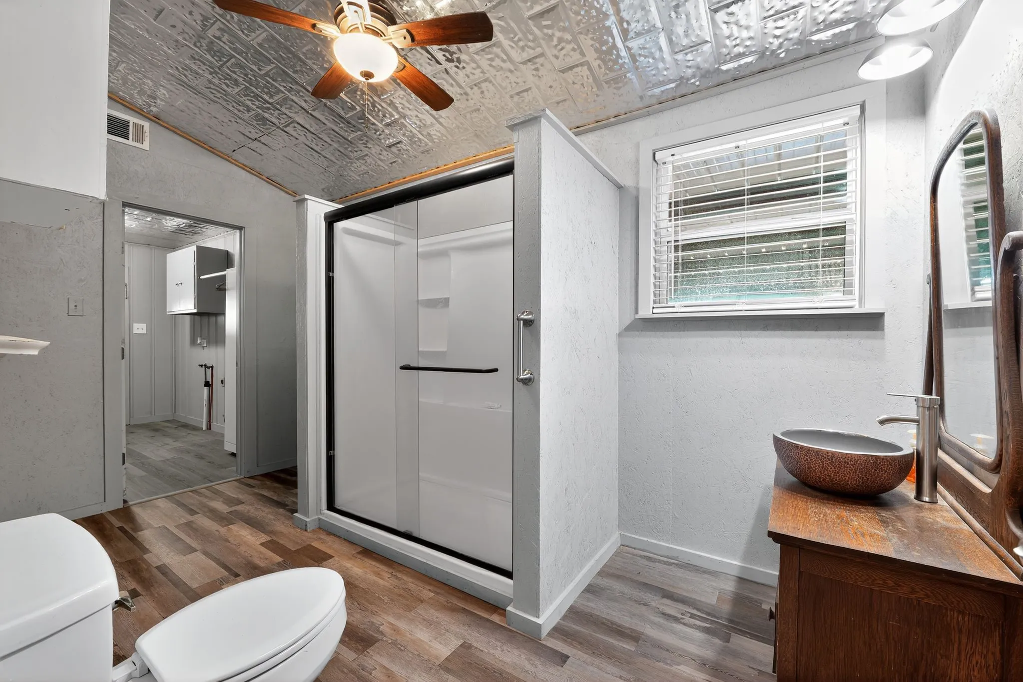 Full bath with an ornate ceiling, a shower stall, wood finished floors, vanity, and a textured​​‌​​​​‌​​‌‌​‌‌​​​‌‌​‌​‌​‌​​​‌​​ wall
