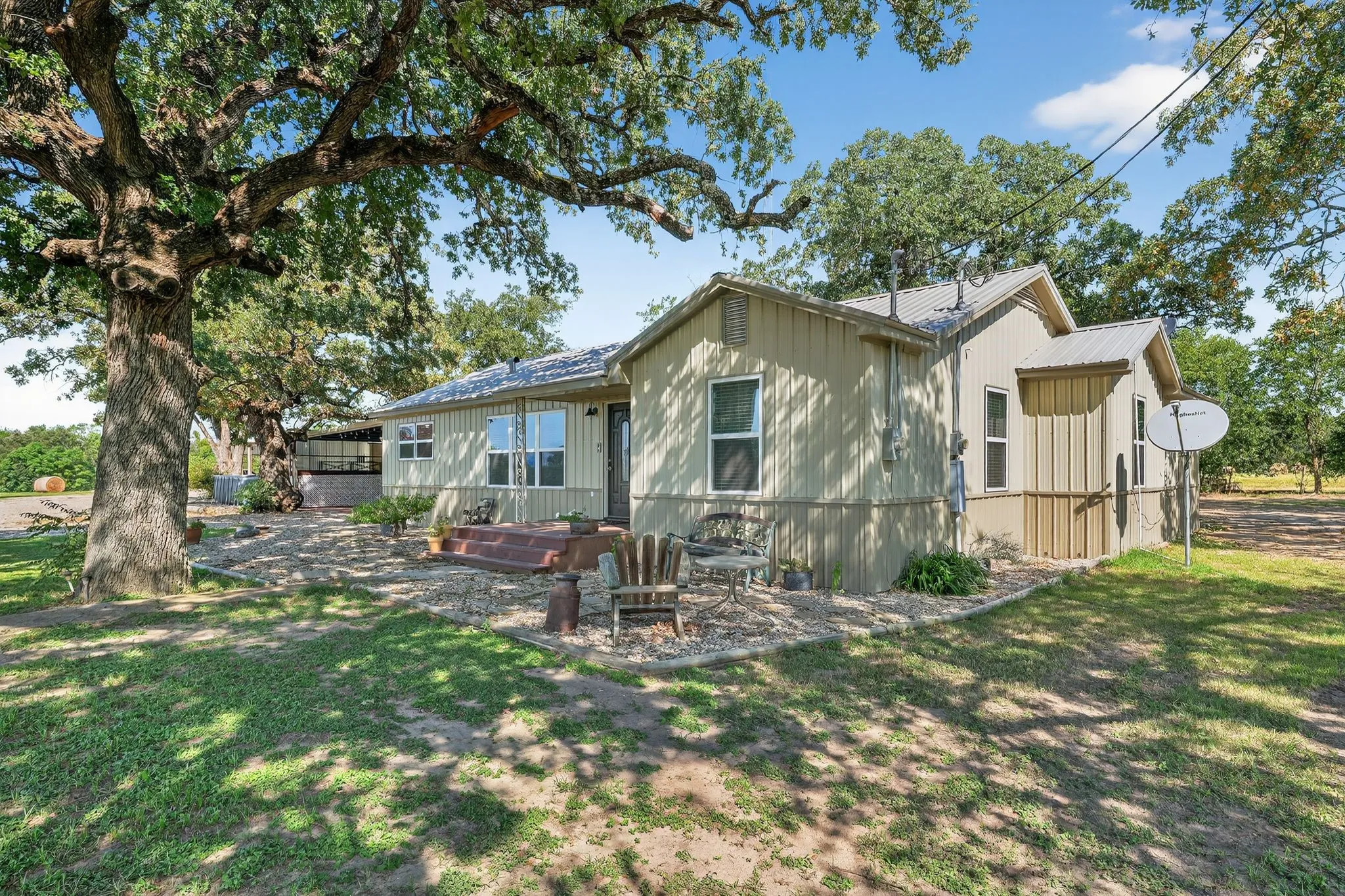 Back of property featuring a patio, a lawn, and a metal roof