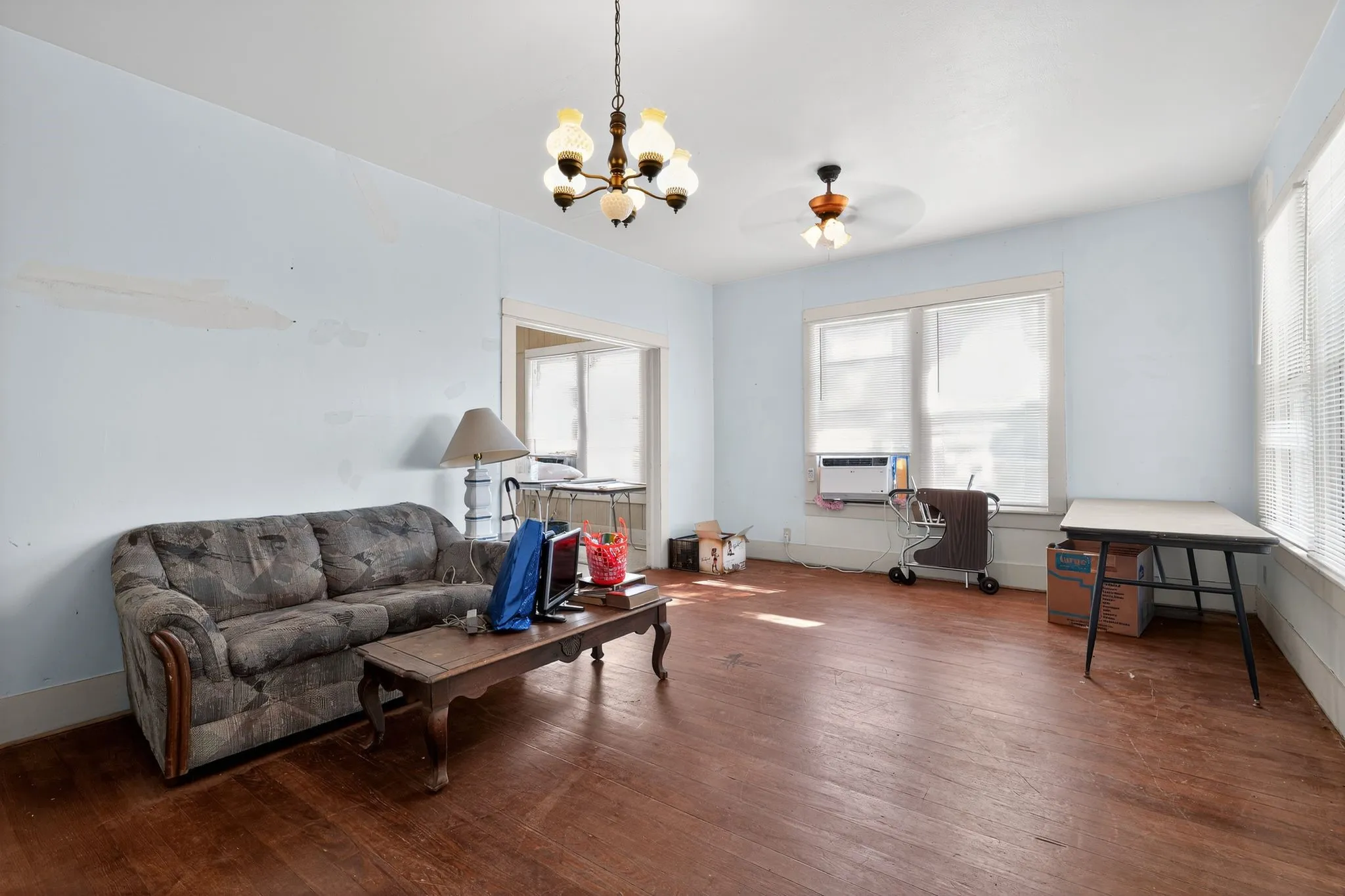 Living area featuring hardwood / wood-style flooring, plenty of natural light, a chandelier, and a ceiling fan