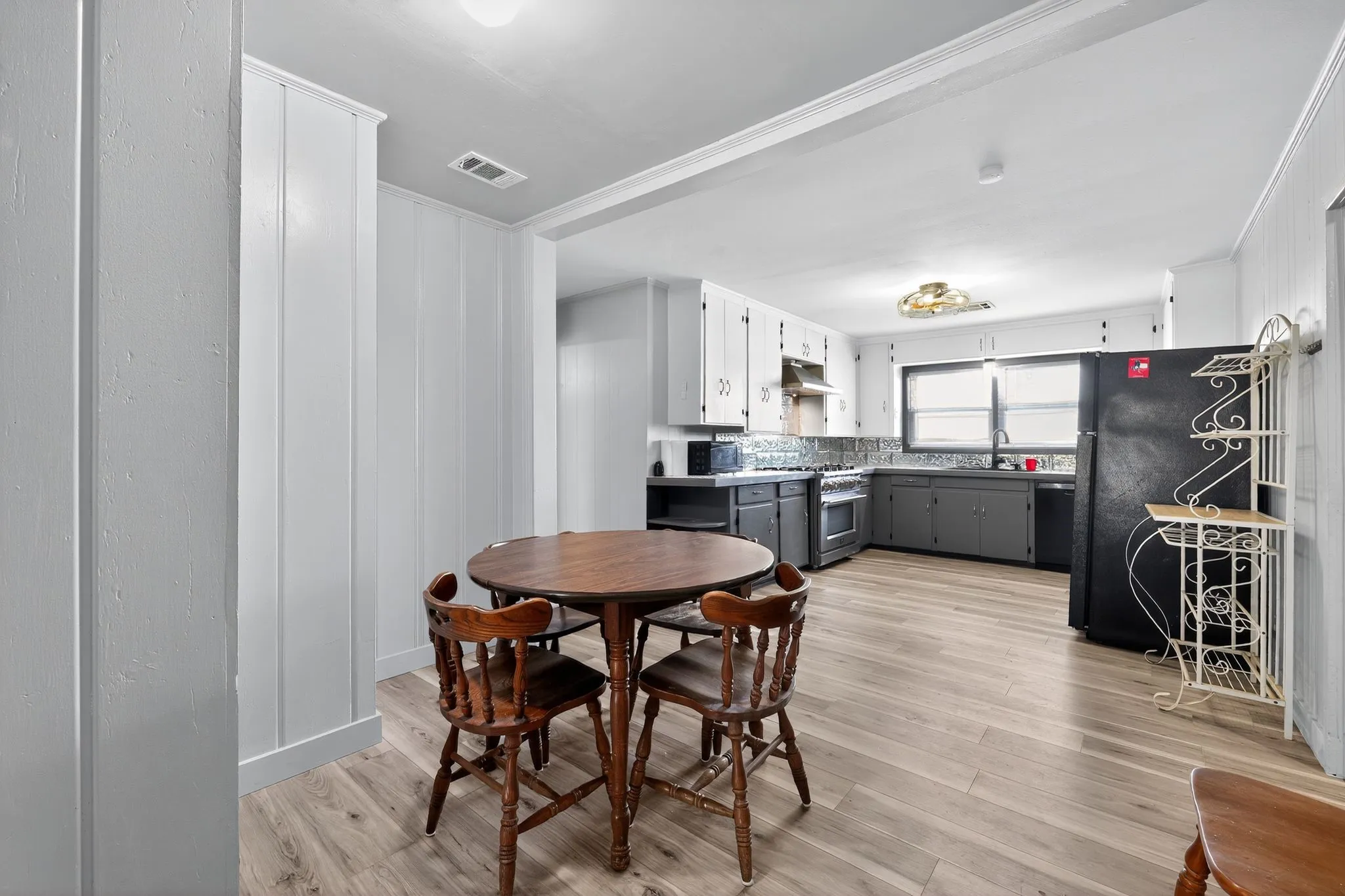Dining space with light wood-style floors and ornamental molding