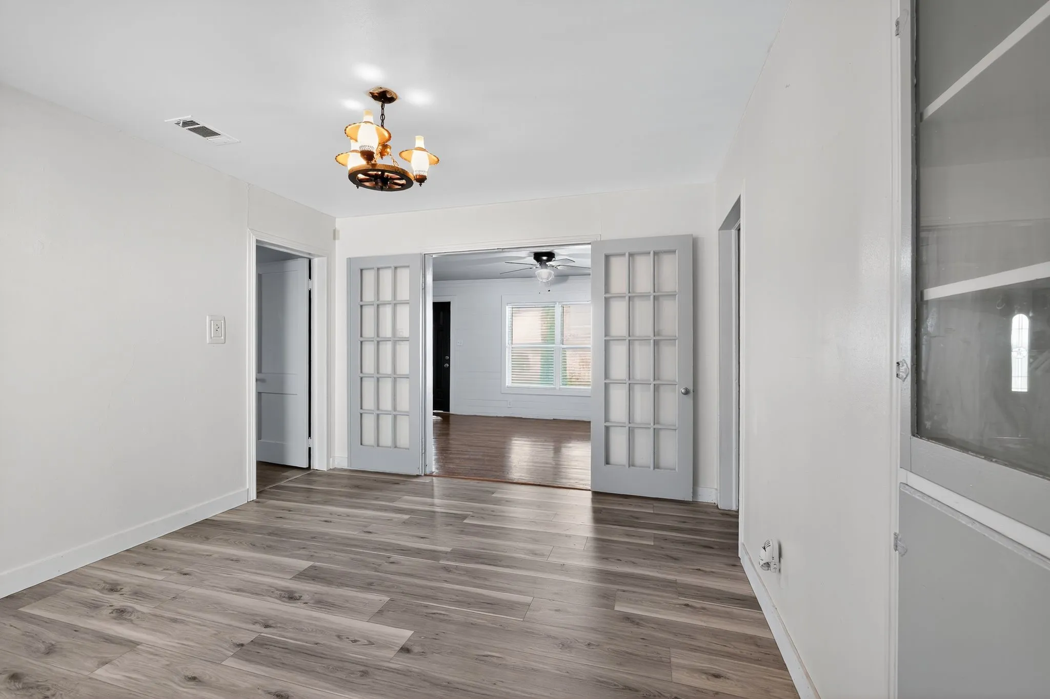 Spare room with a chandelier and wood finished floors