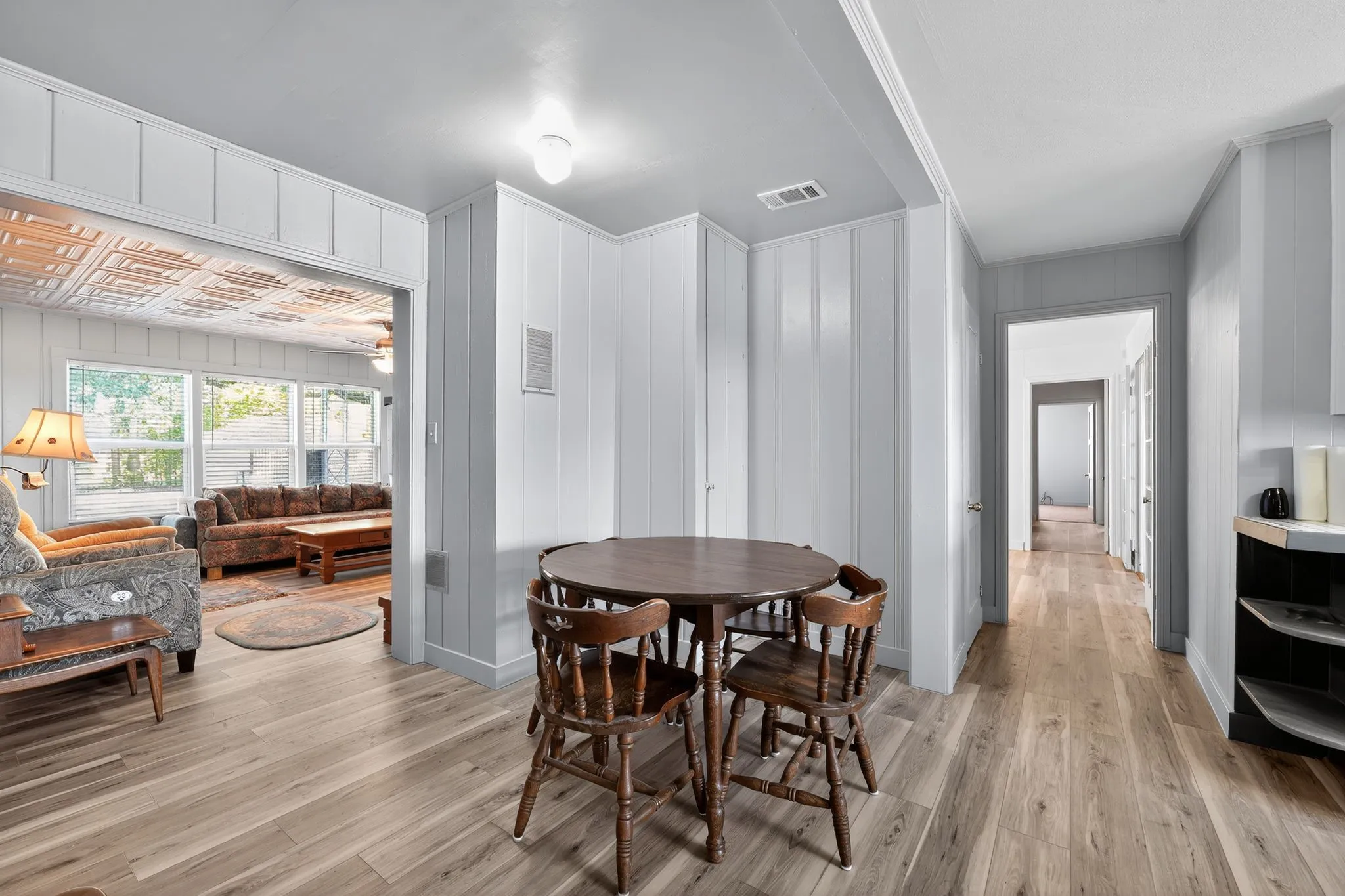 Dining area with light wood-type flooring and wooden walls