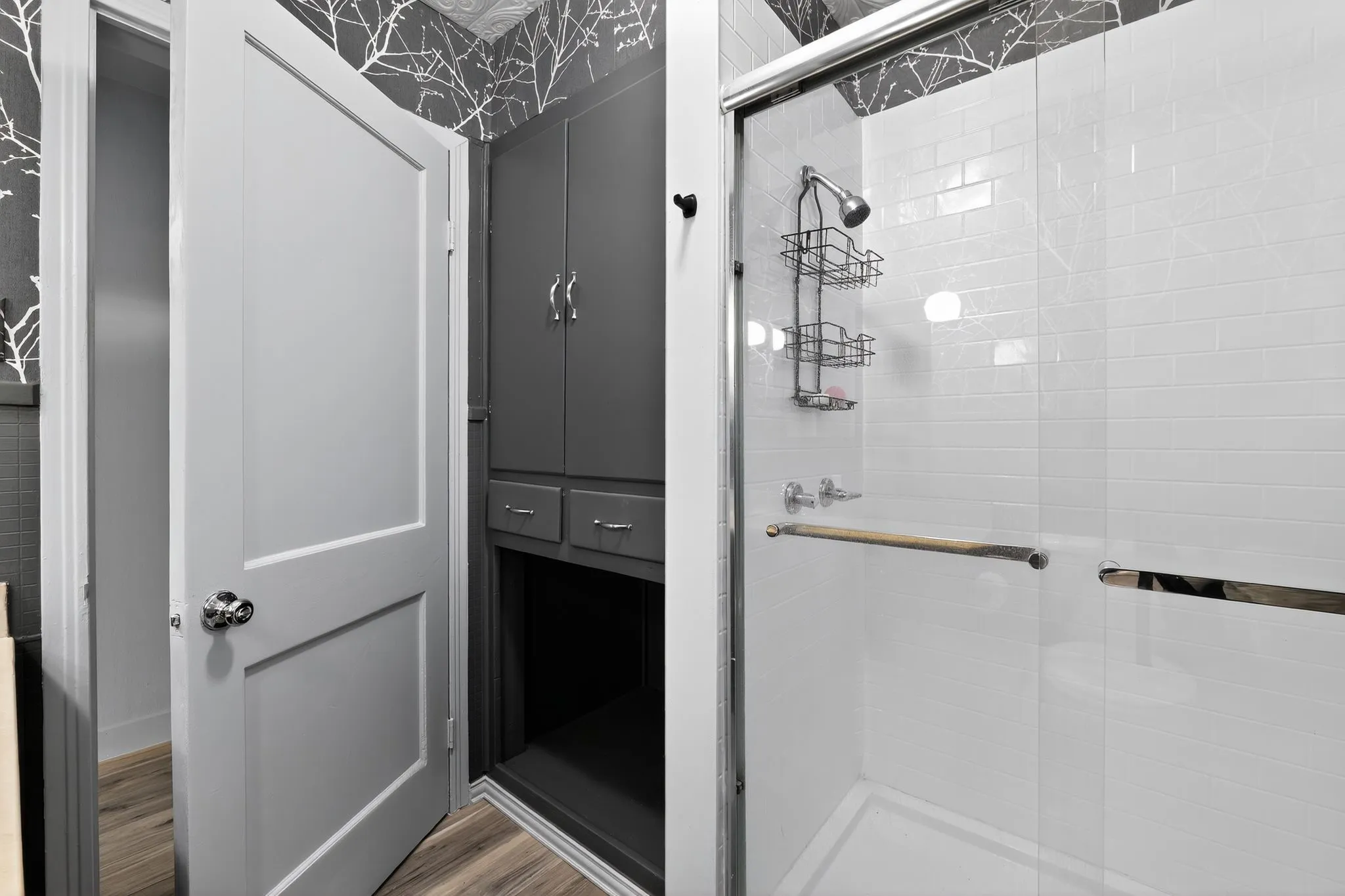 Full bath with a shower stall and light wood finished floors