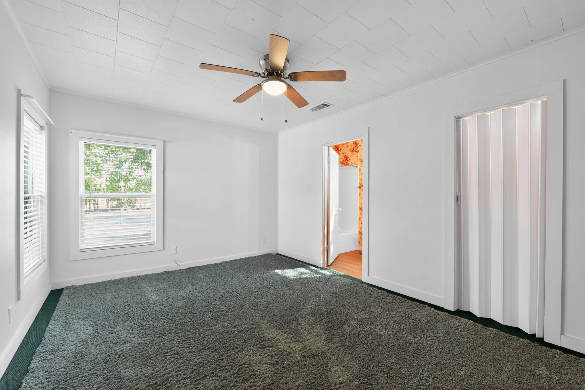 Unfurnished bedroom featuring carpet floors, ceiling fan, and crown molding