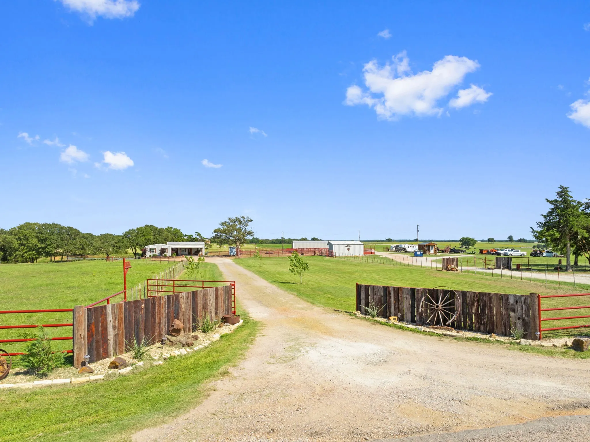 View of dirt / gravel driveway featuring a rural view and a gated entry