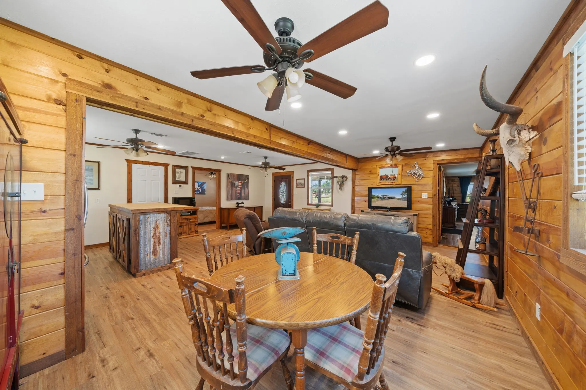 Dining room with wooden walls, recessed lighting, light wood-style floors, and beamed ceiling