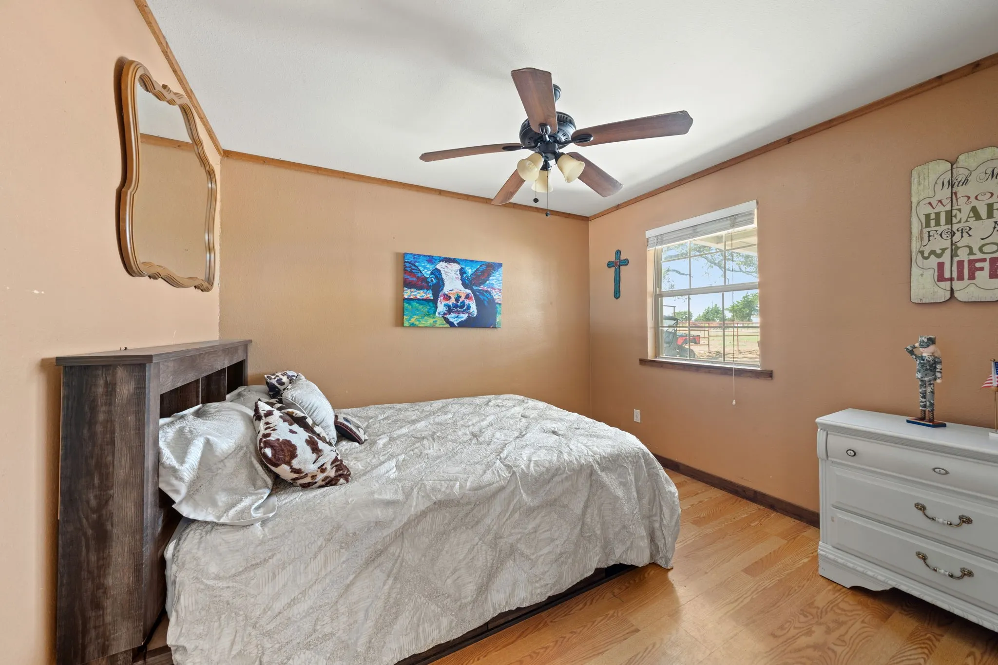 Bedroom featuring ornamental molding, wood finished floors, and a ceiling fan