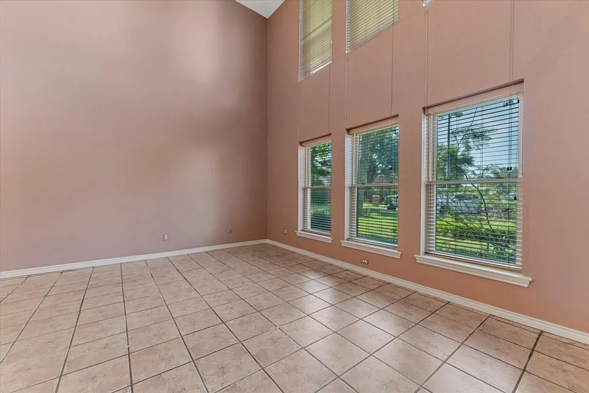 Spare room featuring plenty of natural light, a high ceiling, and light tile patterned flooring