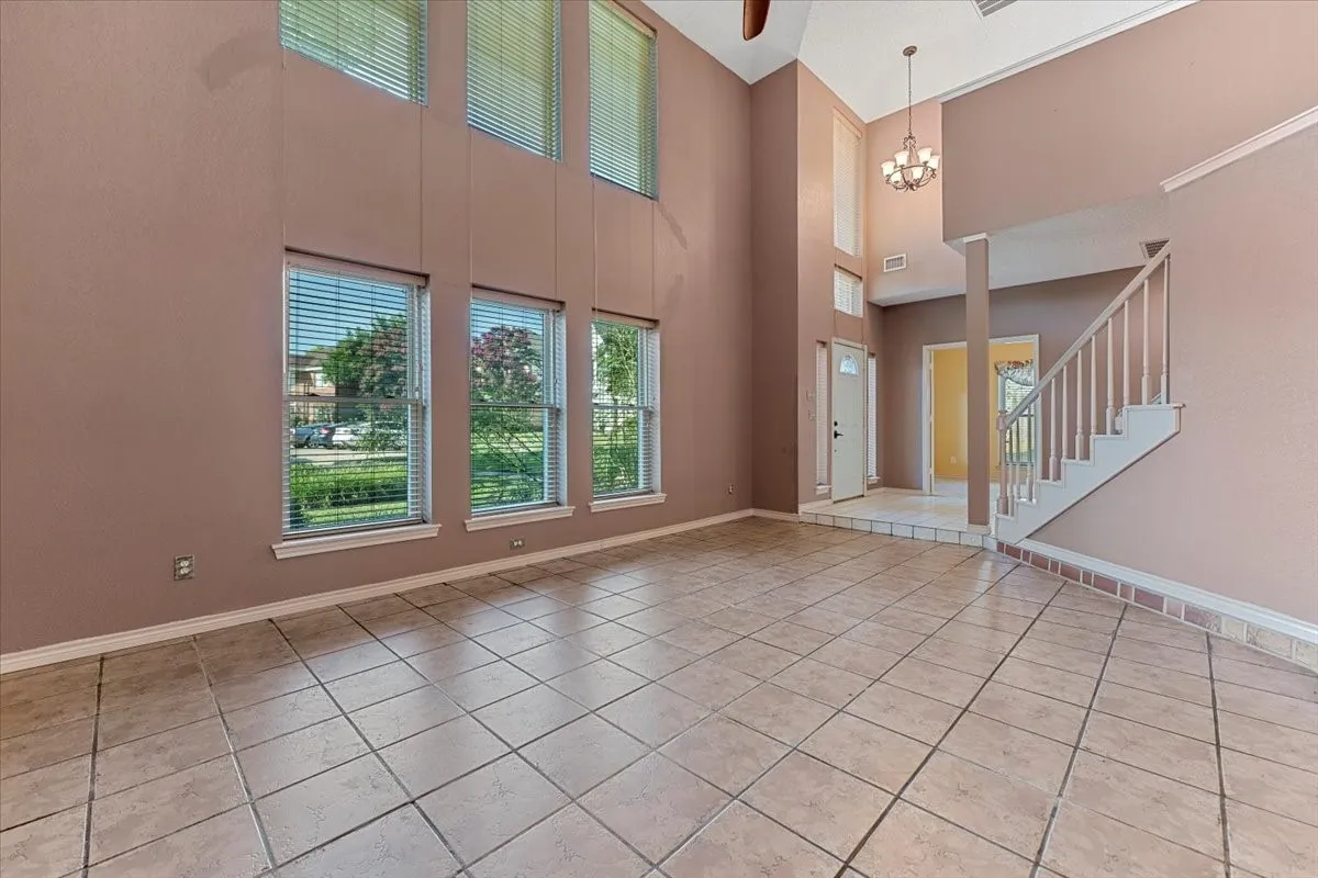 Entrance foyer with plenty of natural light, light tile patterned flooring, and a towering ceiling