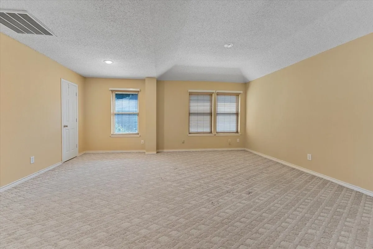 Spare room with light colored carpet, a textured ceiling, and recessed lighting