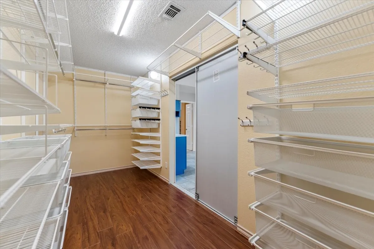 Walk in closet featuring dark wood-style flooring