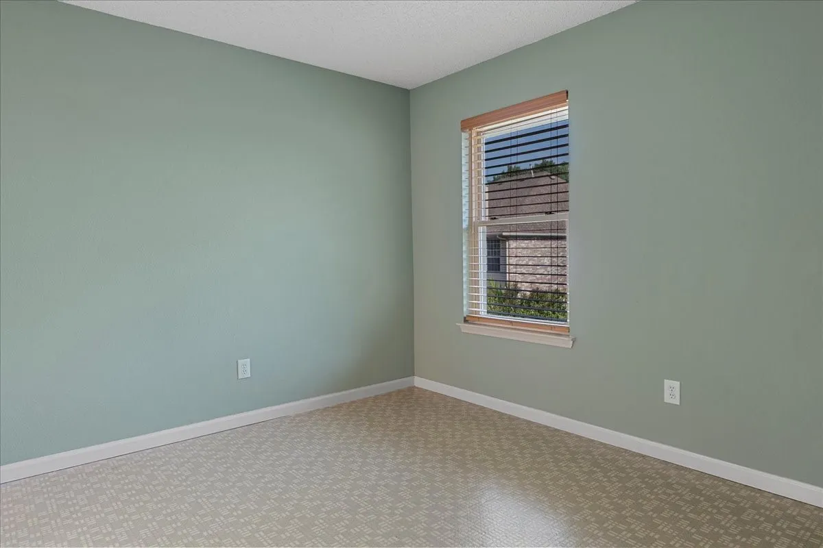 Empty room featuring a textured ceiling and baseboards