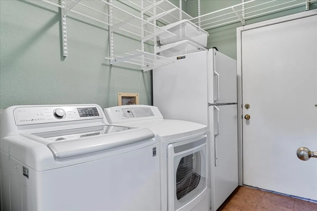 Washroom with independent washer and dryer and tile patterned floors