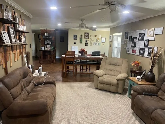 Living room with crown molding, recessed lighting, carpet flooring, and ceiling fan
