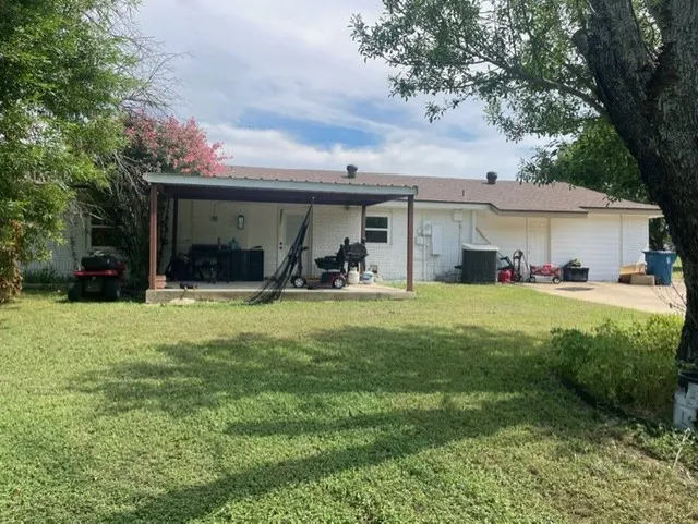 Rear view of house with a patio area and a lawn