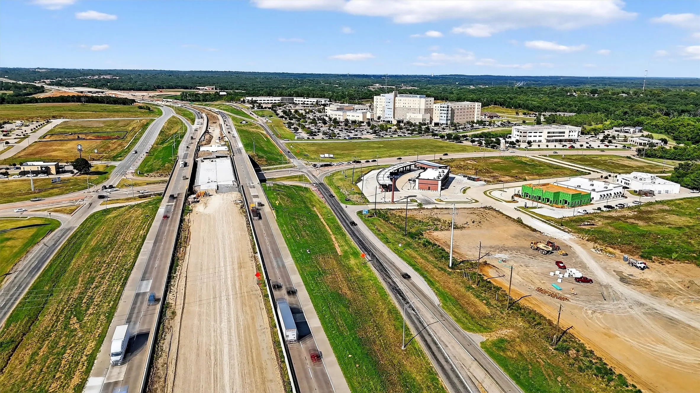 Aerial view of property and surrounding area featuring a main thoroughfare