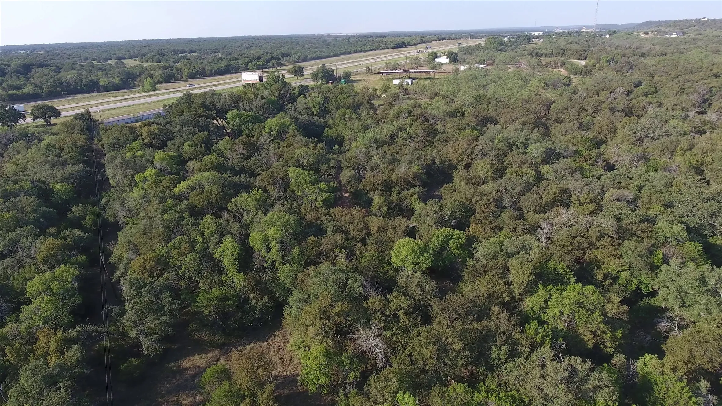 View of property location with a heavily wooded area
