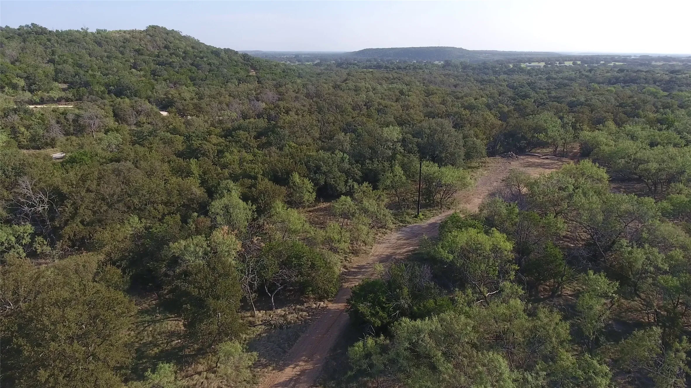 Aerial overview of property's location with a heavily wooded area