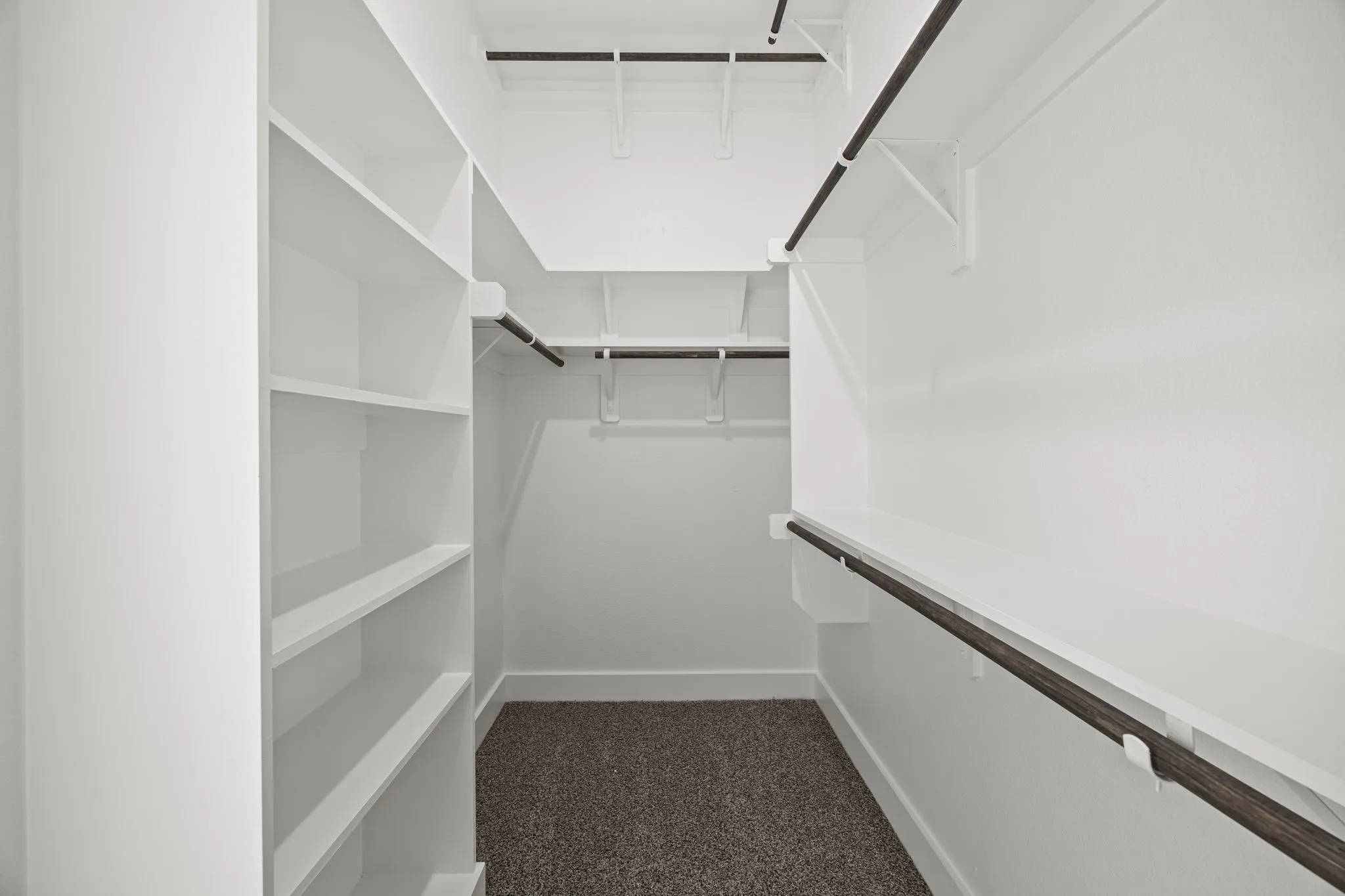 Walk in closet with dark carpet