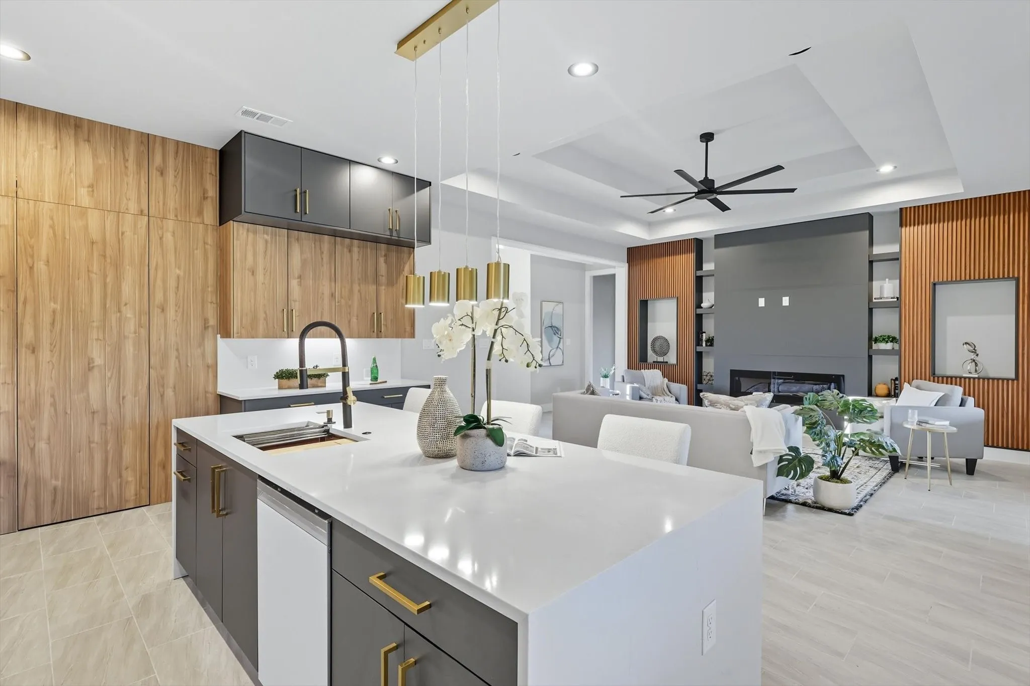 Kitchen with wood walls, hanging light fixtures, modern cabinets, gray cabinetry, and light stone counters