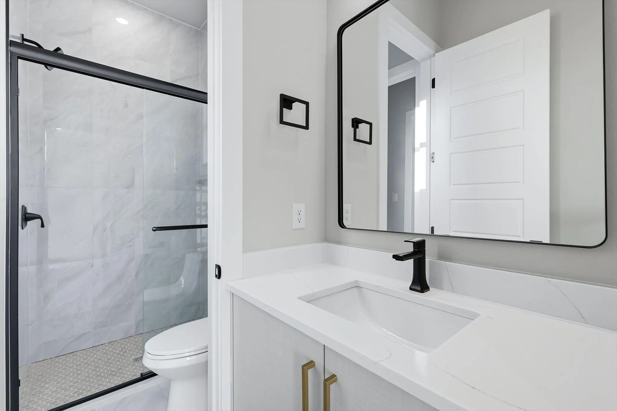Bathroom with vanity and a marble finish shower