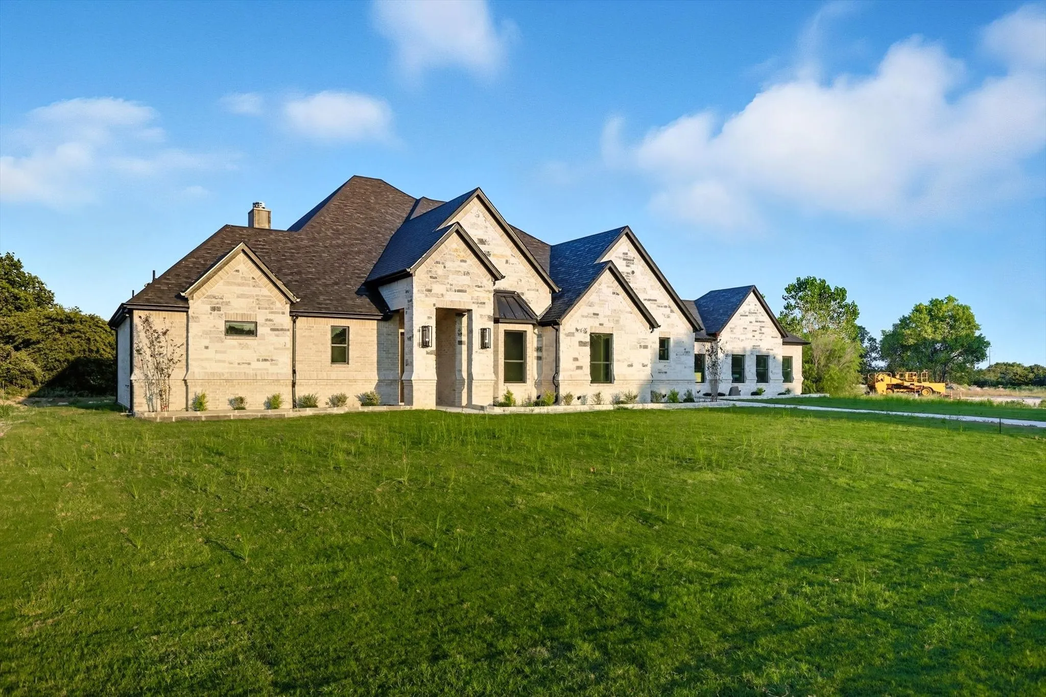 French country inspired facade with a front yard, a chimney, and brick siding
