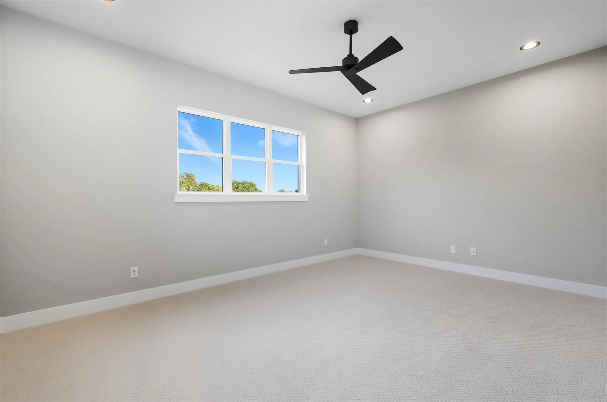 Carpeted spare room featuring ceiling fan and recessed lighting