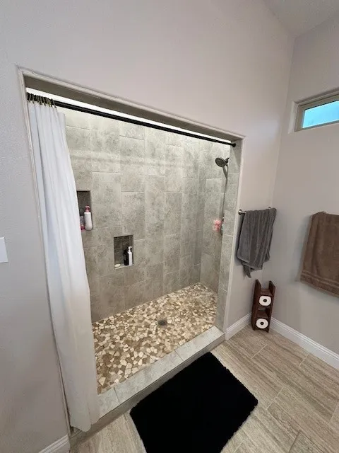 Full bathroom with a shower stall and wood tiled floors