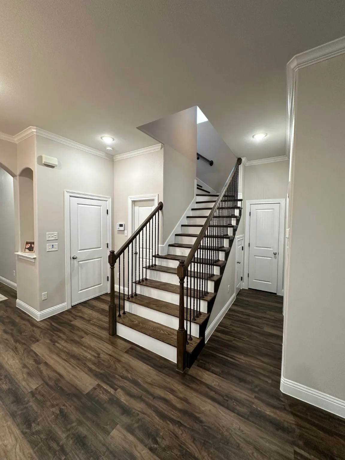 Stairs featuring crown molding and wood finished floors