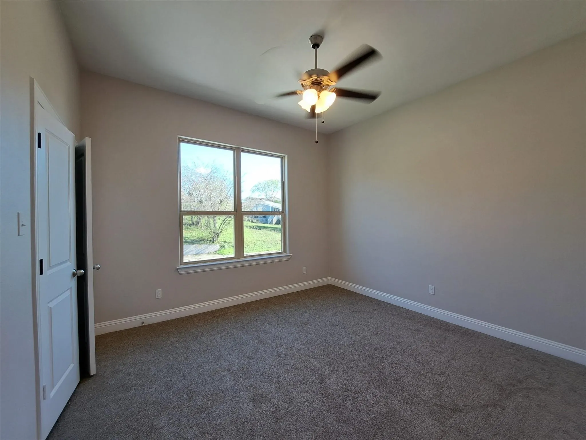 Unfurnished room with carpet flooring and a ceiling fan