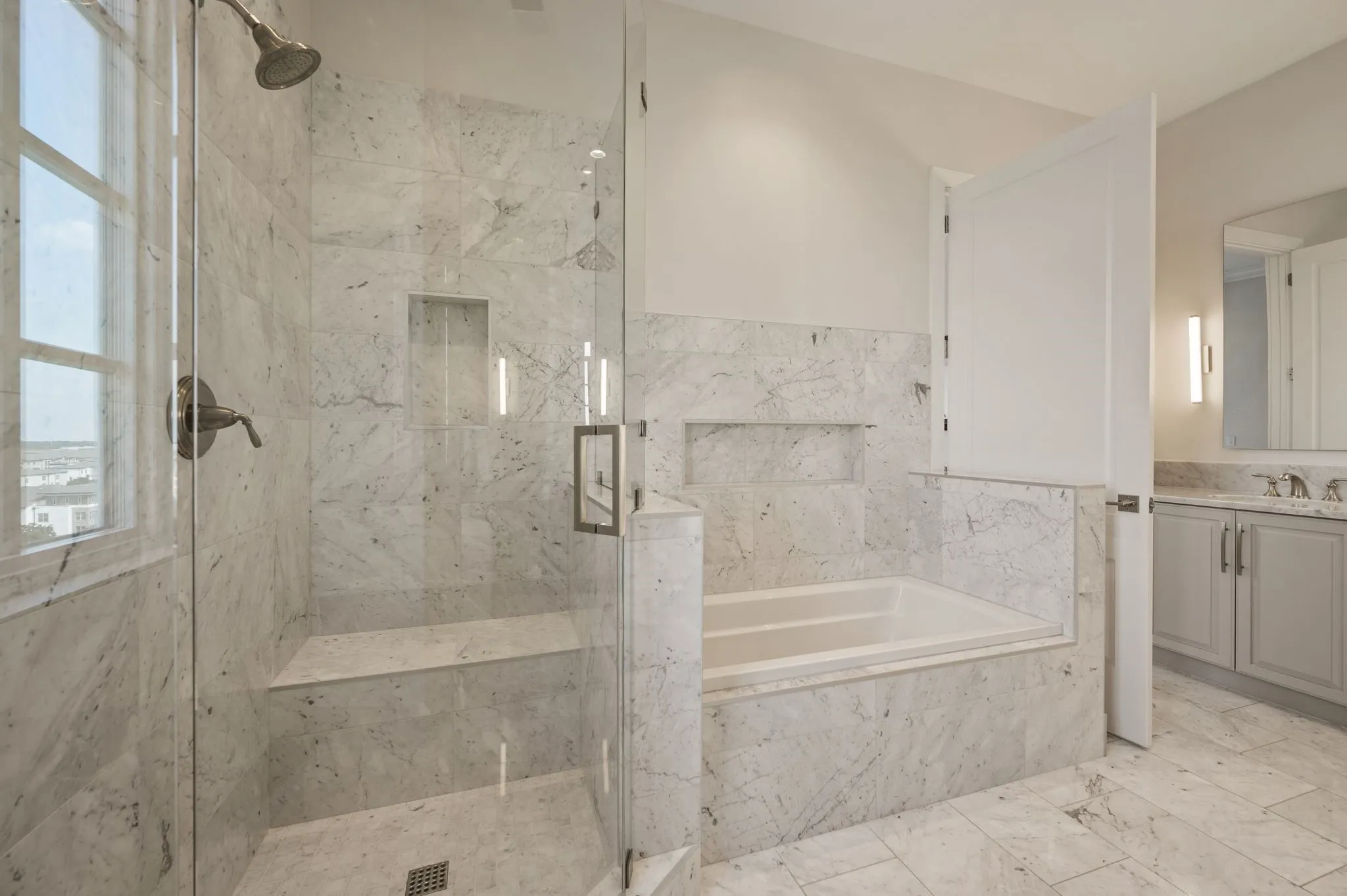 Full bath with a marble finish shower, vanity, and a bath