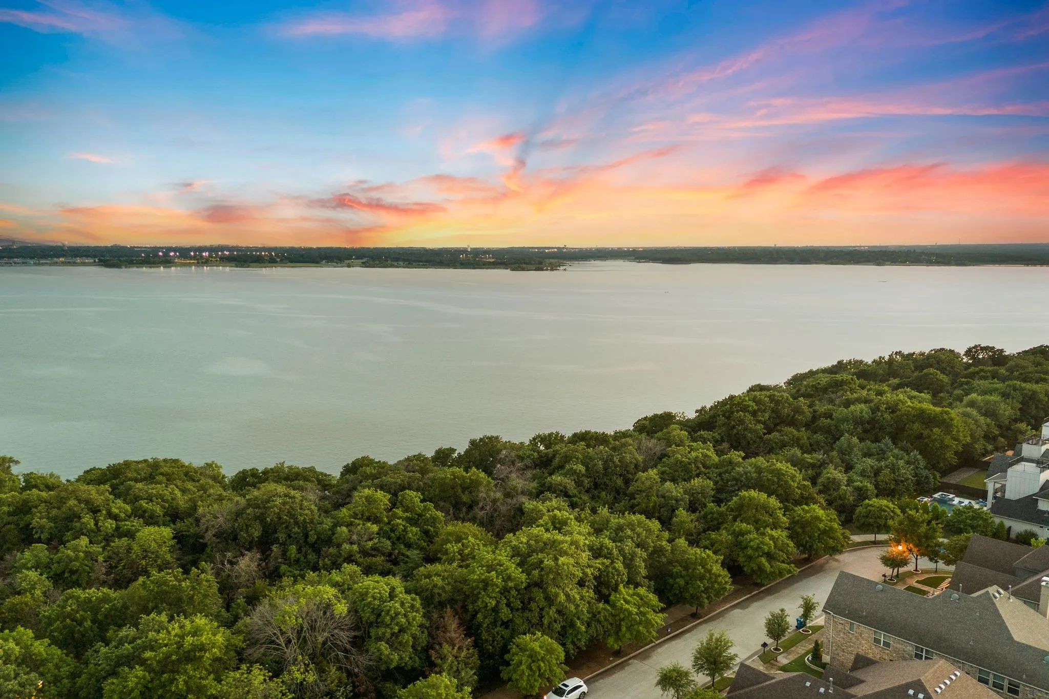 Aerial view at dusk featuring a water view and a forest view