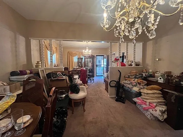 Carpeted dining area featuring a chandelier